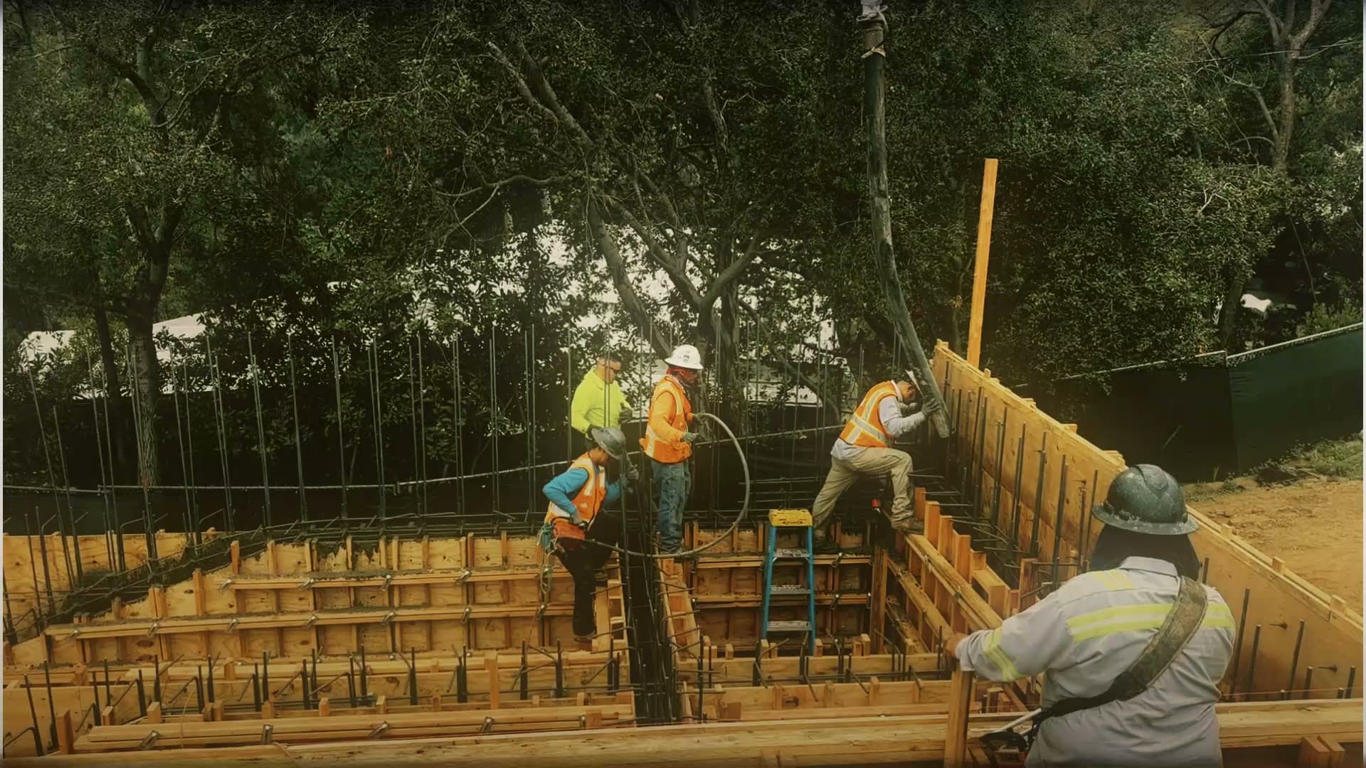 EMAE & Sons crews placing formwork, rebar cages and pumped concrete on a hillside foundation in Brentwood